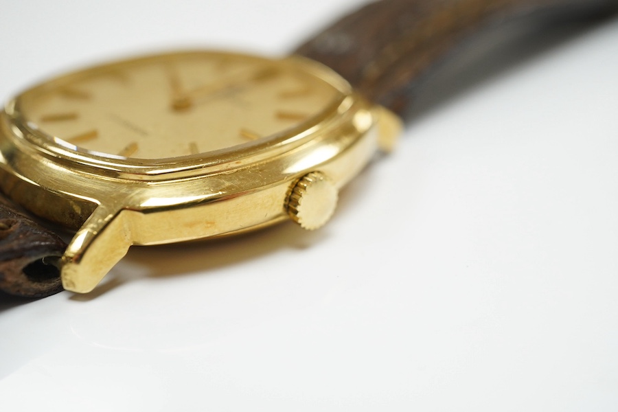 A gentleman's 18k gold Universal Unisonic quartz wrist watch, with baton numerals, case diameter 33mm, on an associated strap. Condition - poor to fair